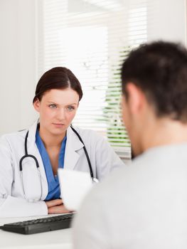 A female doctor and a patient with a prescription in an office