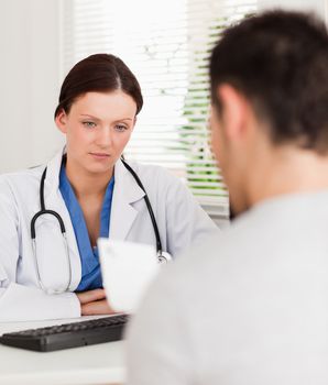 A female doctor and her patient are sitting in an office whilst patient reads prescription