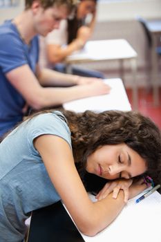 Portrait of a student sleeping on her desk in a classroom