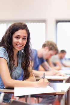 Portrait of a serious student writing in a classroom