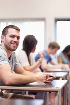 Portrait of a smiling young man in a classroom