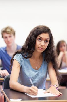 Portrait of a focused student taking notes in a classroom