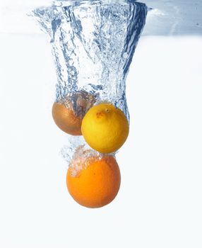 Fresh kiwi, orange, lemon  fruits in water splash 