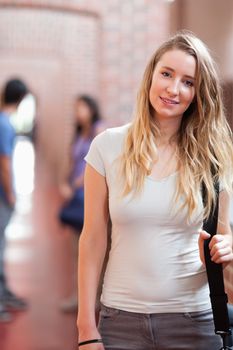 Portrait of a beautiful student posing in a corridor