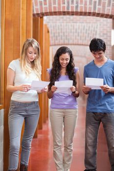 Portrait of students reading a piece of paper in a corridor