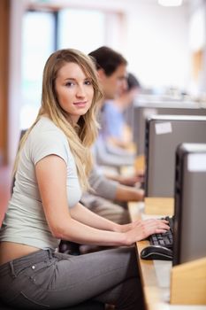 Portrait of a blonde student using a computer in an IT room