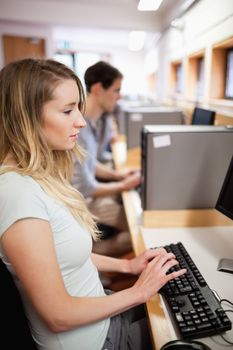 Portrait of a serious student working with a computer in an IT room