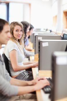 Portrait of fellow students in an IT room with the camera focus on a model