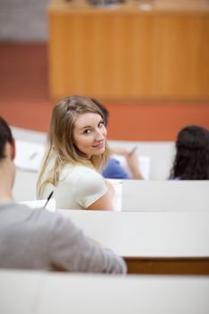 Portrait of a student being distracted in an amphitheater