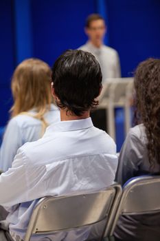 Portrait of young people listening to a man doing a presentation