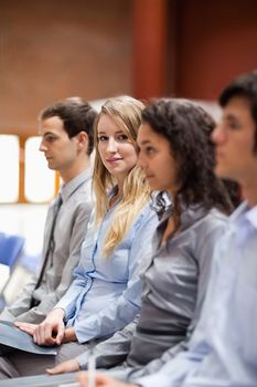 Portrait of a young businesswoman smiling at the camera during a presentation