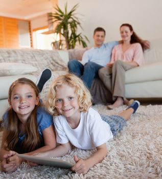 Children on the carpet using tablet together