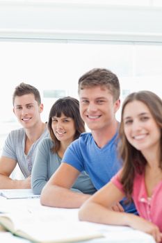 A close up side view shot of smiling students looking and turned to the camera 