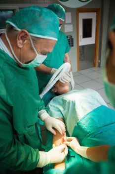 Surgeon using a scalpel to open a patient in a surgical room