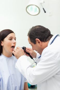 Doctor auscultating the mouth of his patient in an examination room