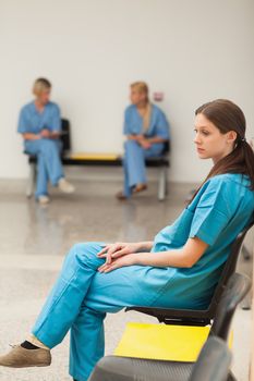 Intern waiting on a chair in hospital waiting room