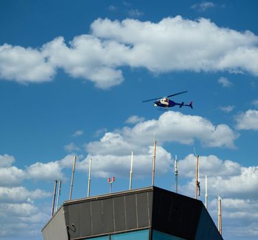 A helicopter hovering over an airport control tower