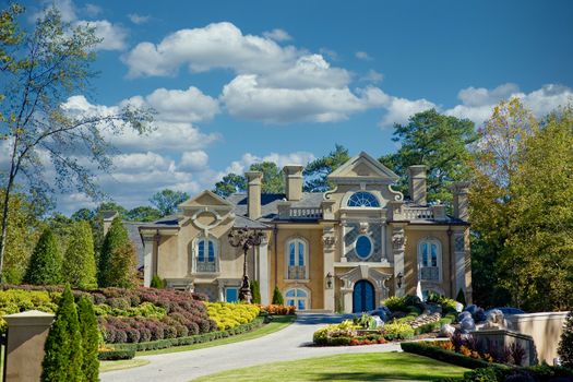 A nice large stucco house on a hill in the autumn