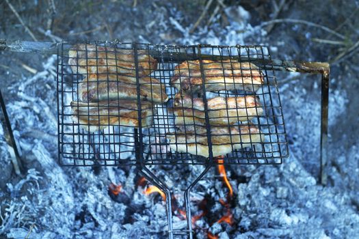 Barbeque from pork prepared outdoors on a hot summer day in a camp