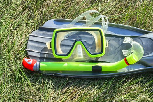 underwater mask, snorkel, and flippers lying on the grass. diver equipment