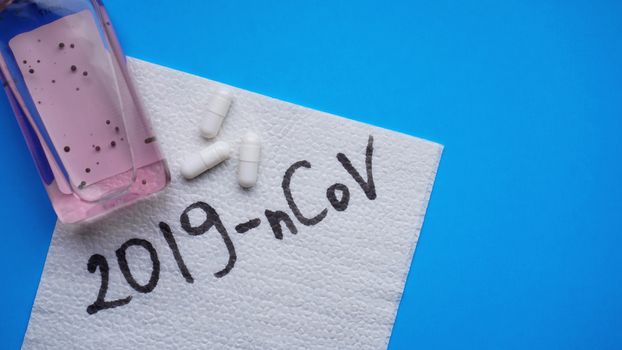 Coronavirus in China. New coronavirus 2019-nCoV. Napkin, antiseptic and pills on blue background. Virus prevention