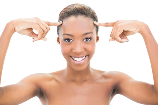 Cheerful natural beauty pointing at forehead on white background