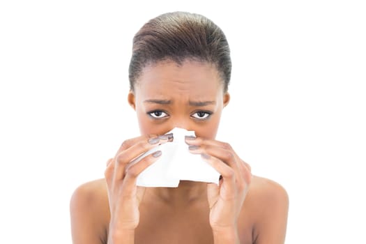 Worried natural beauty blowing her nose on white background