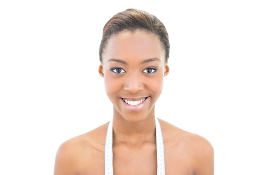 Smiling natural beauty with measuring tape over the neck on white background