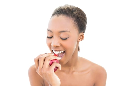 Natural beauty with closed eyes biting apple on white background