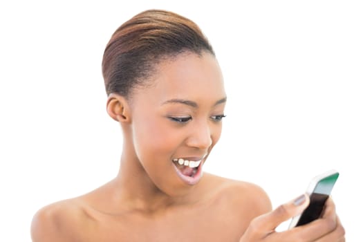 Happy natural beauty looking at her smartphone on white background