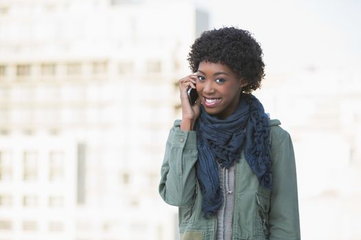Cheerful afro model on the phone outdoors on a sunny day