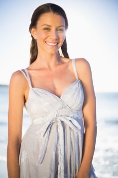 Happy gorgeous woman in summer dress posing on the beach at dusk