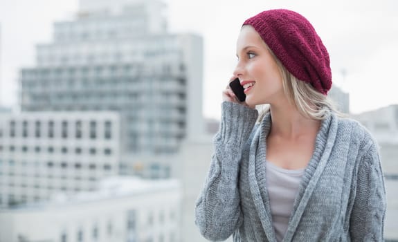Happy pretty blonde on the phone outdoors on urban background