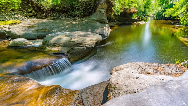 At the Felsenbad, a natural water pool with small waterfalls at lake Schussen in Upper Swabia