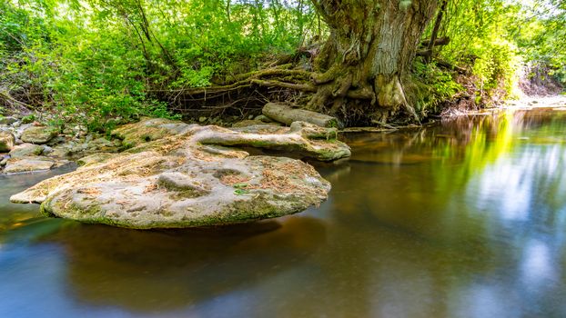 At the Felsenbad, a natural water pool with small waterfalls at lake Schussen in Upper Swabia