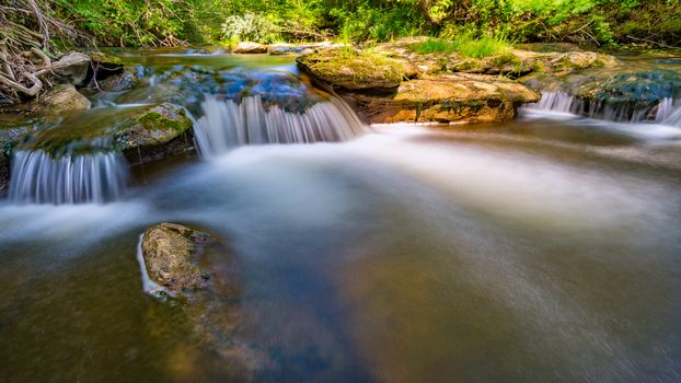 At the Felsenbad, a natural water pool with small waterfalls at lake Schussen in Upper Swabia