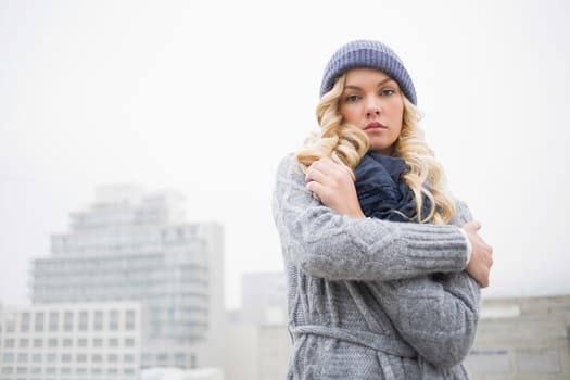 Cold gorgeous blonde posing outdoors on urban background