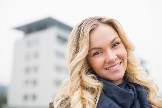 Happy attractive blonde posing outdoors on urban background