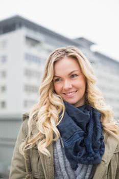 Cheerful casual blonde posing outdoors on urban background