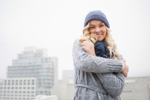 Smiling gorgeous blonde posing outdoors on urban background
