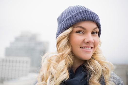 Smiling attractive blonde posing outdoors on urban background