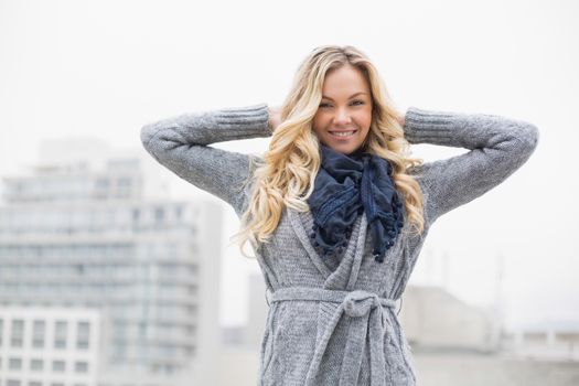 Smiling beautiful blonde posing outdoors on urban background