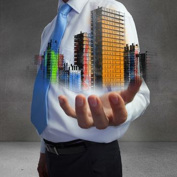 Close up of hand showing colorful holographic city in grey room