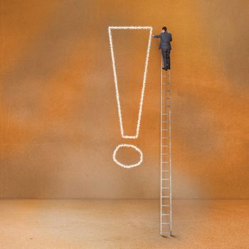 Rear view of businessman standing on ladder touching exclamation mark 