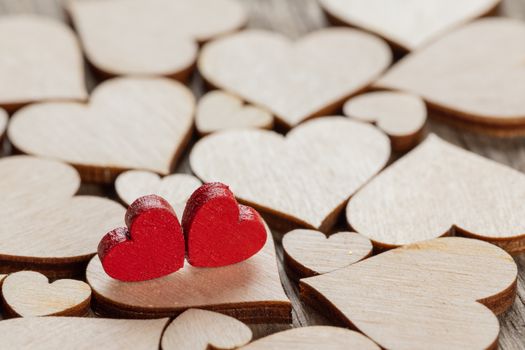 Many wooden colorless hearts background, two red special ones true love concept