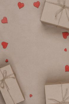 Boxes with gifts wrapped in brown craft paper and red paper hearts Valentines day concept