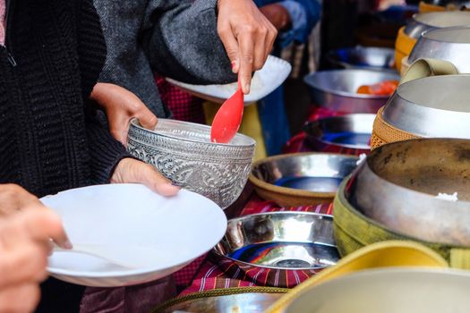 Give alms, to offer food to the monks