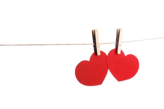 Clothes pegs and two red paper hearts on rope isolated on white background Valentines day concept