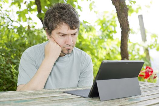 casual man working with a tablet pc, outdoor