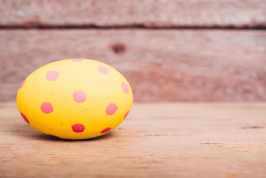 Beautiful Easter Yellow egg on wooden background, Easter day concept